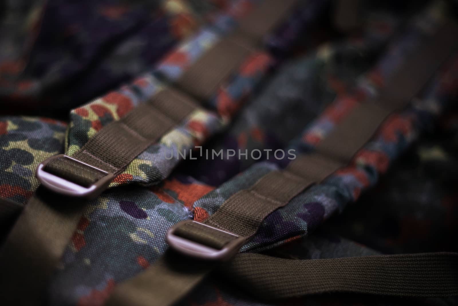 Military camouflage roomy backpack. In the frame of the strap and the back of a backpack. Close-up view.
