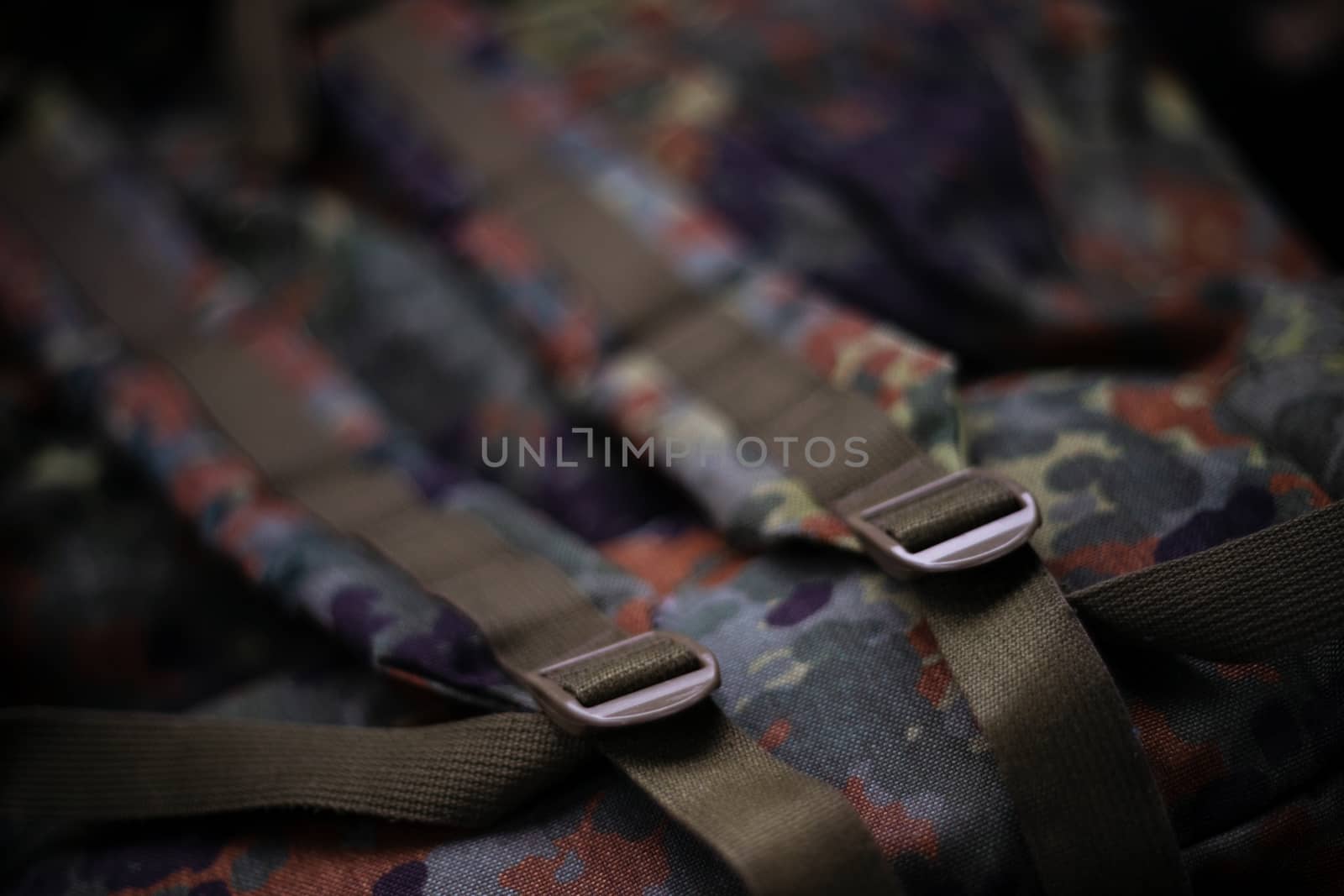 Military camouflage roomy backpack. In the frame of the strap and the back of a backpack. Close-up view.