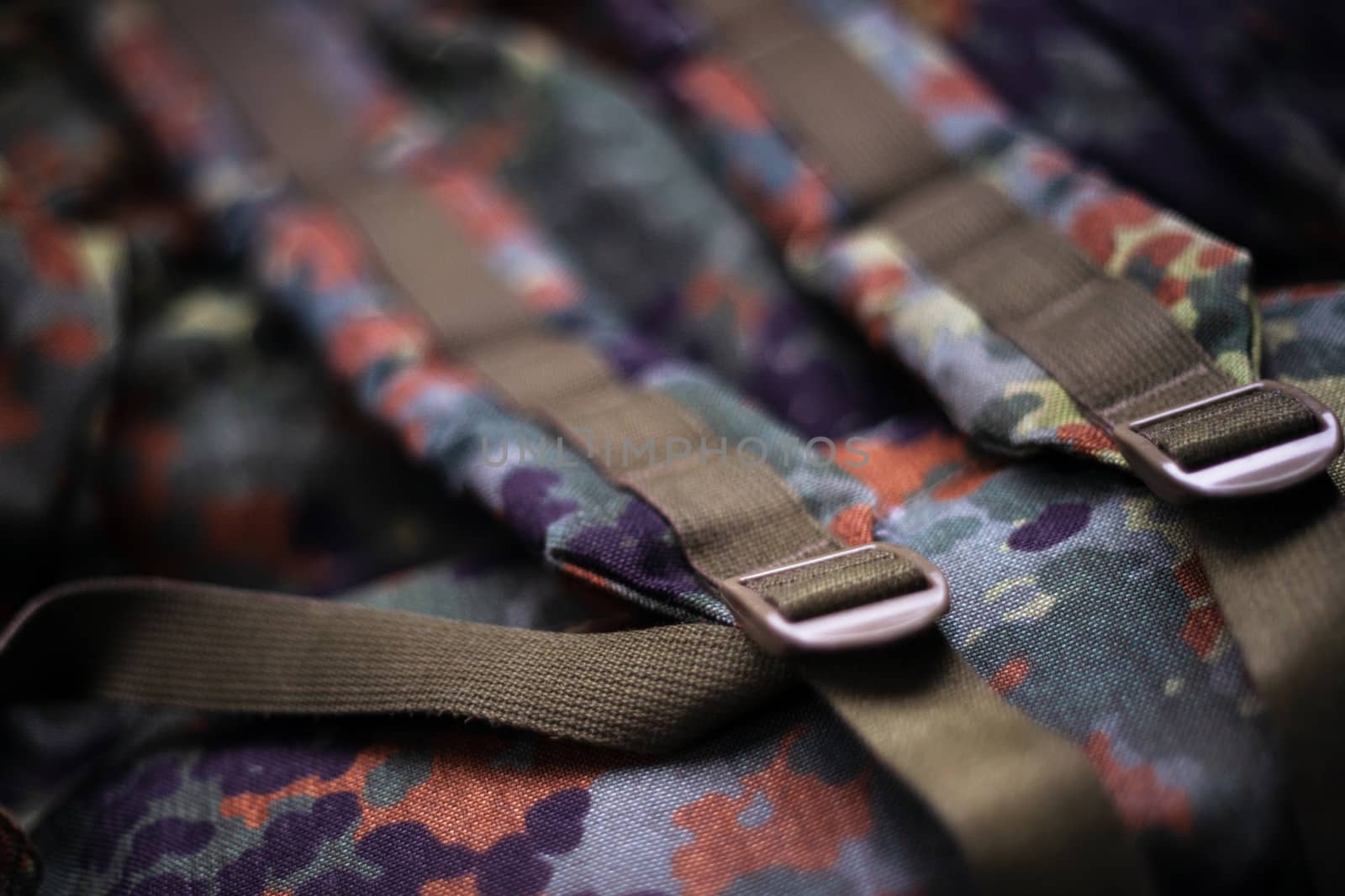 Military camouflage roomy backpack. In the frame of the strap and the back of a backpack. Close-up view.