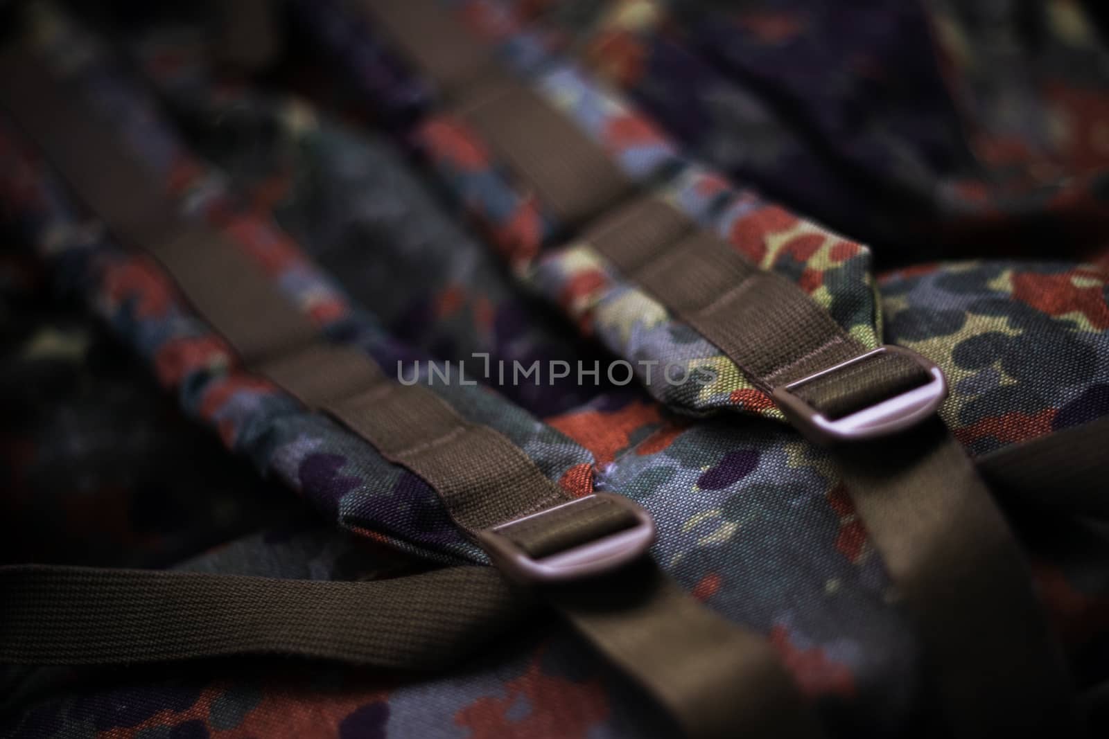 Military camouflage roomy backpack. In the frame of the strap and the back of a backpack. Close-up view.