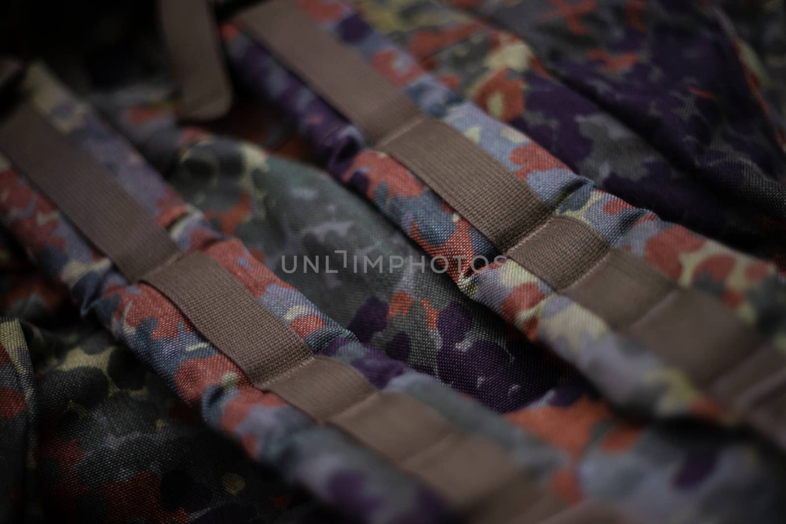 Military camouflage roomy backpack. In the frame of the strap and the back of a backpack. Close-up view.