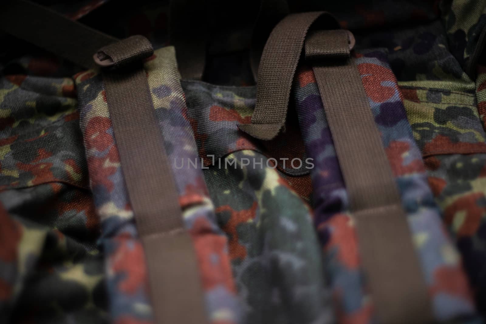 Military camouflage roomy backpack. In the frame of the strap and the back of a backpack. Close-up view.