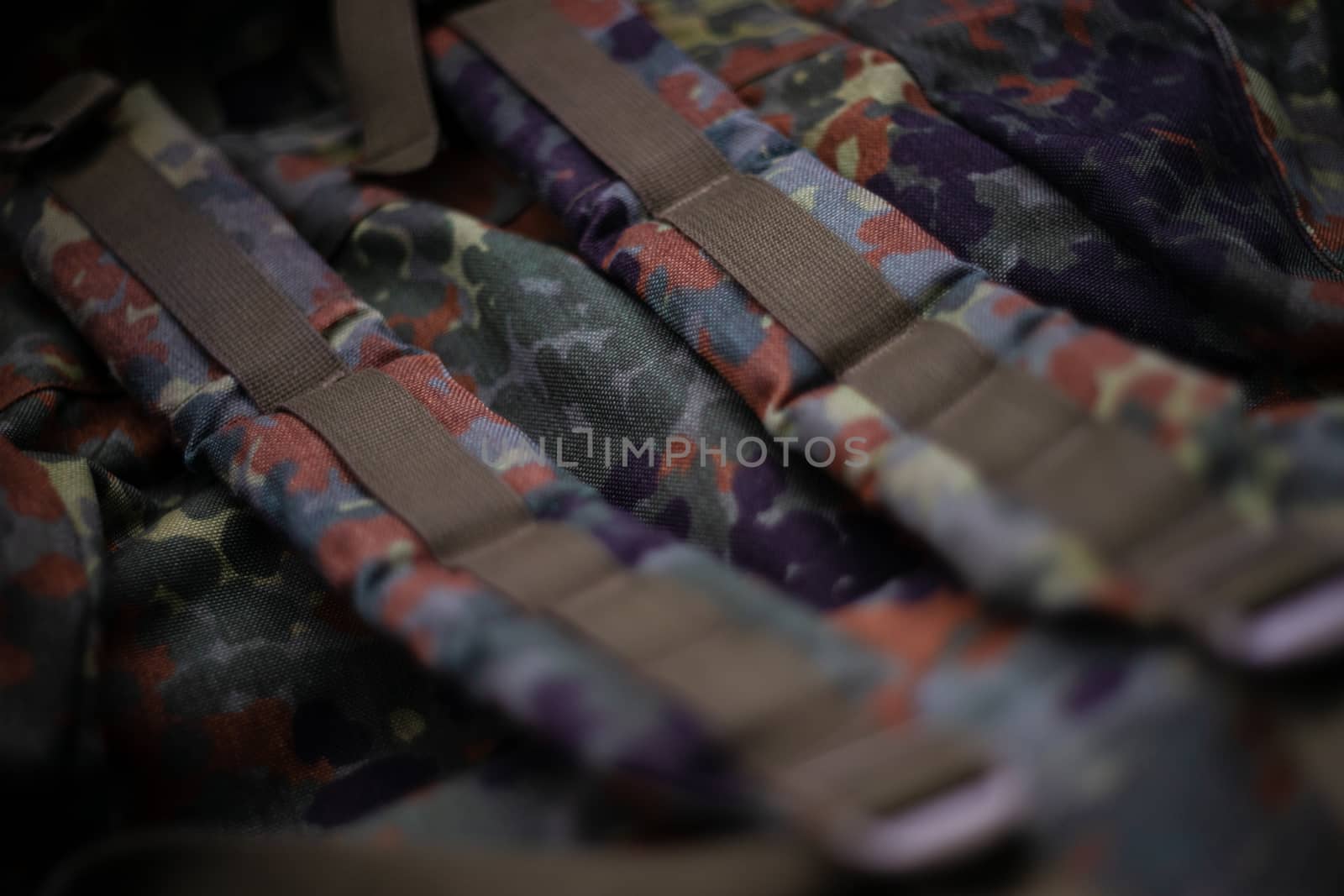 Military camouflage roomy backpack. In the frame of the strap and the back of a backpack. Close-up view.