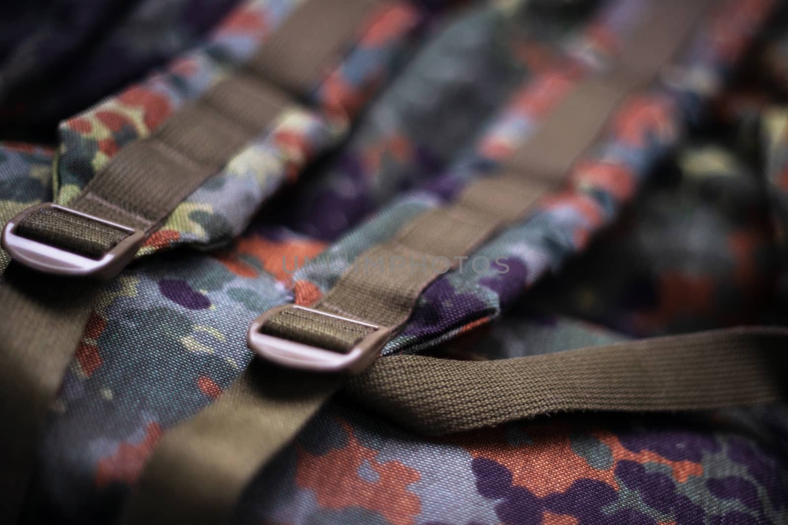 Military camouflage roomy backpack. In the frame of the strap and the back of a backpack. Close-up view.