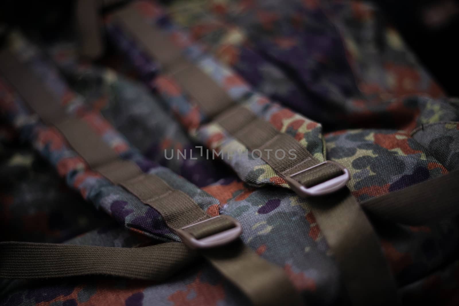 Military camouflage roomy backpack. In the frame of the strap and the back of a backpack. Close-up view.