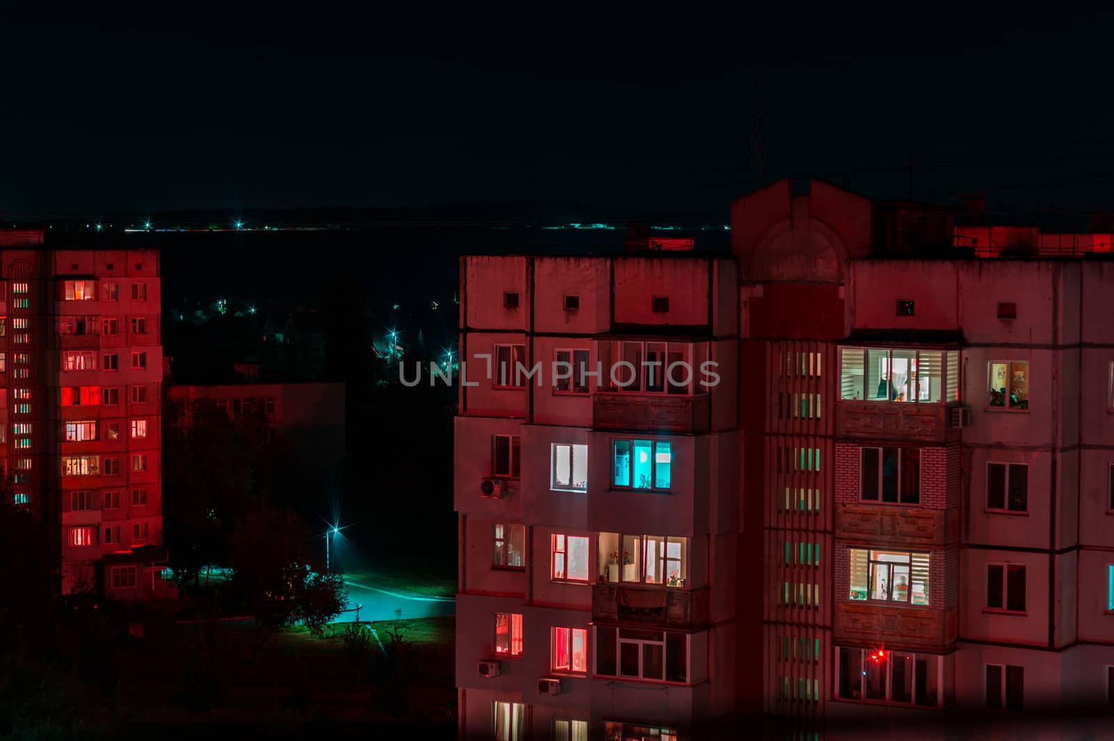 Long exposure photo of high-rise buildings in red and blue lights. Night cityscape. Big city life.