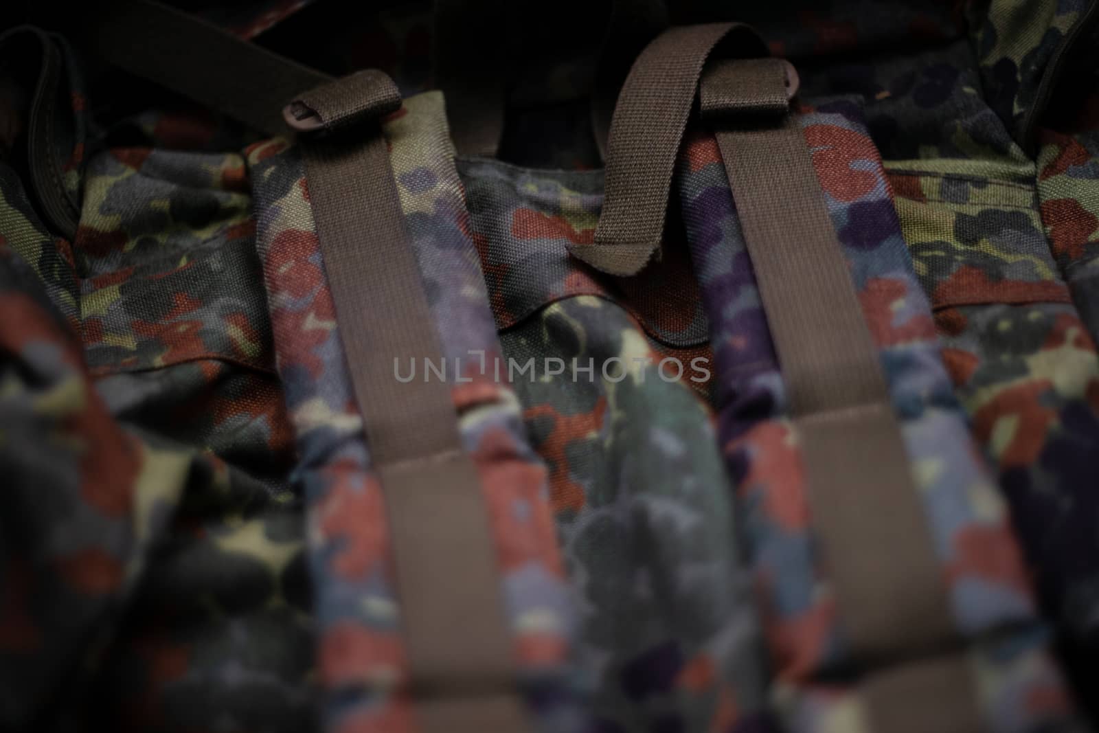 Military camouflage roomy backpack. In the frame of the strap and the back of a backpack. Close-up view.