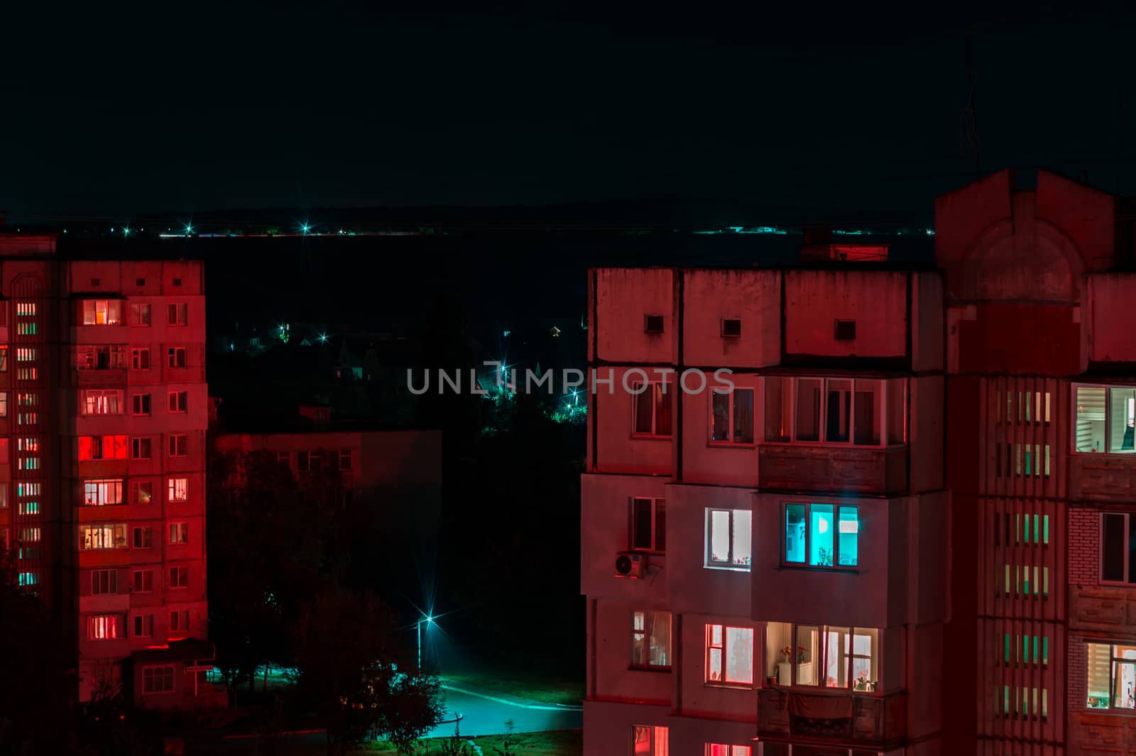 Long exposure photo of high-rise buildings in red and blue lights. Night cityscape. Big city life.