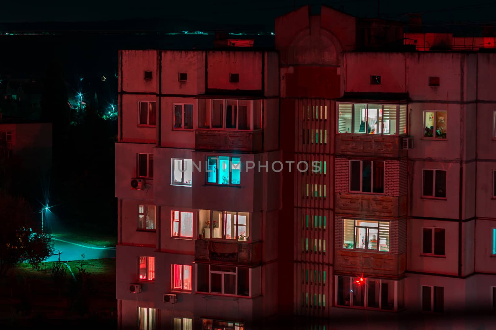 Long exposure photo of high-rise buildings in red and blue lights. Night cityscape. Big city life.