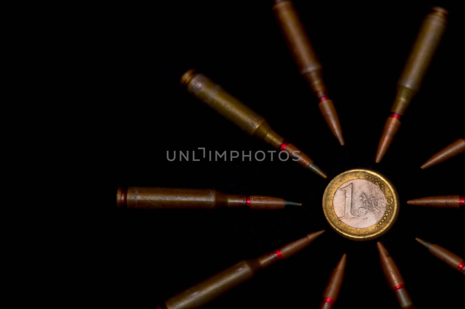 Rifle ammo around one euro coin on black background. Symbolizes the war for money and one of the world's problems. by alexsdriver