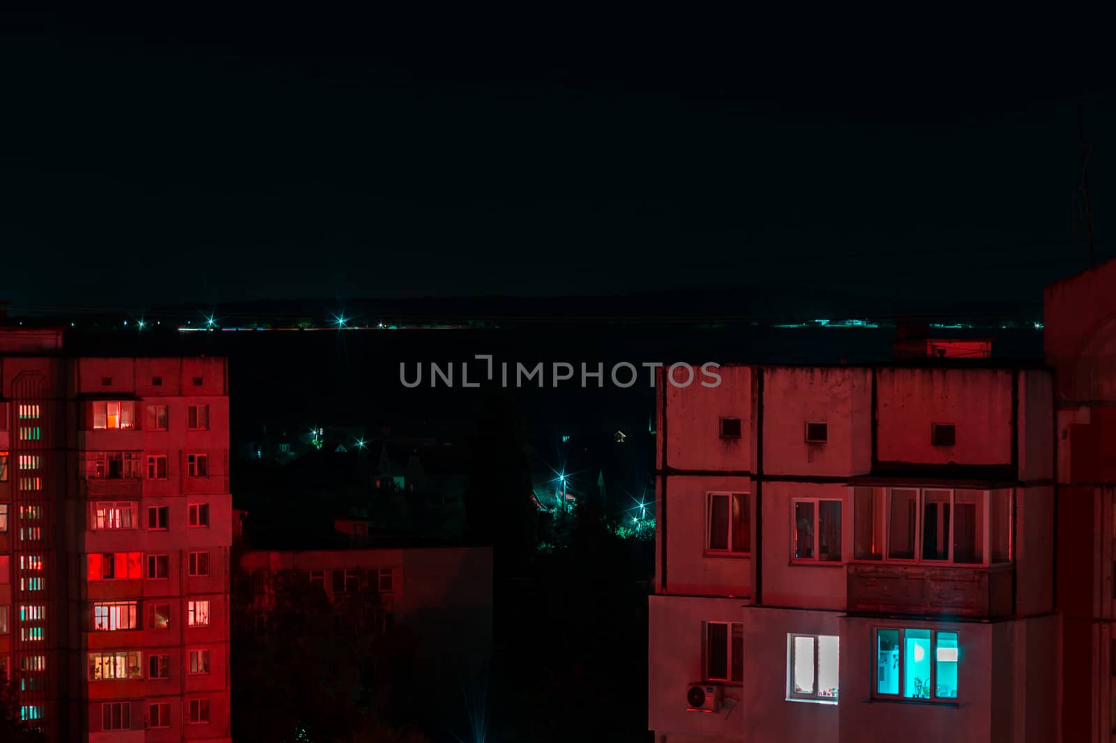Long exposure photo of high-rise buildings in red and blue lights. Night cityscape. Big city life.