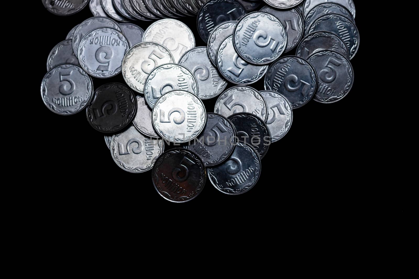 Ukrainian coins isolated on black background. Close-up view. Coins are located above the center of frame. A conceptual image.