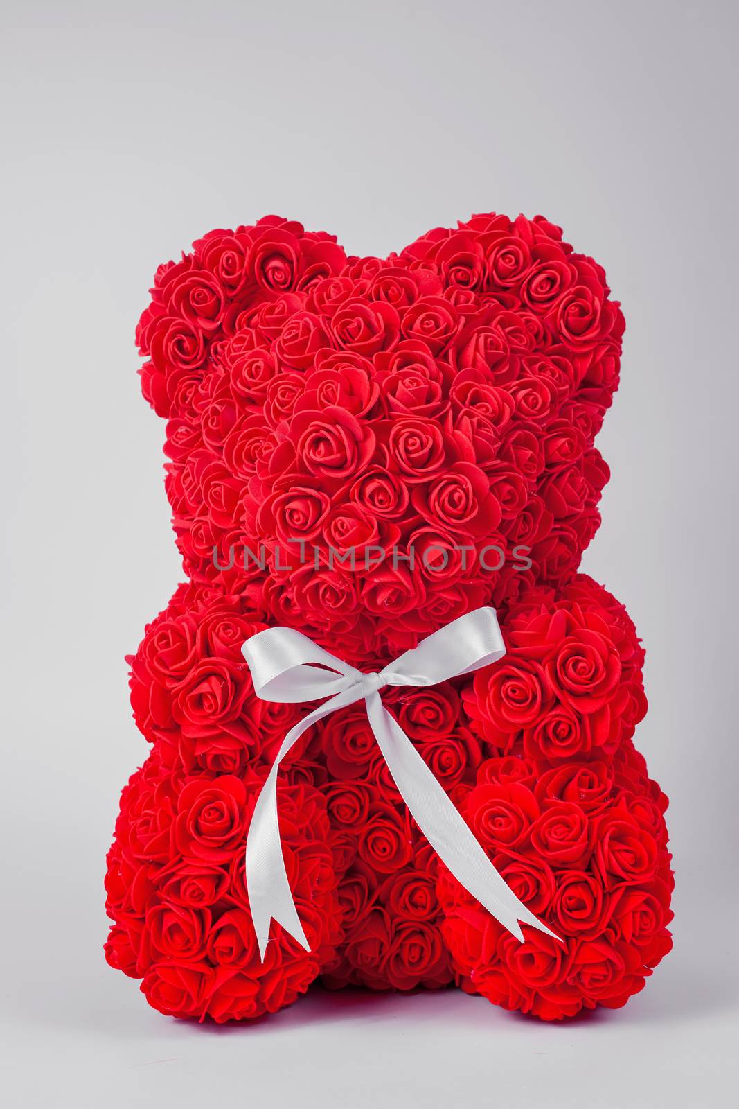 Red  teddy bear toy of foamirane roses. White stripe on teddy neck. Stock photo isolated on white background.