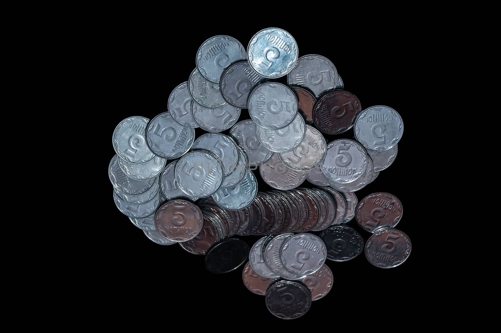 Small Ukrainian coins isolated on black background. Close-up view.