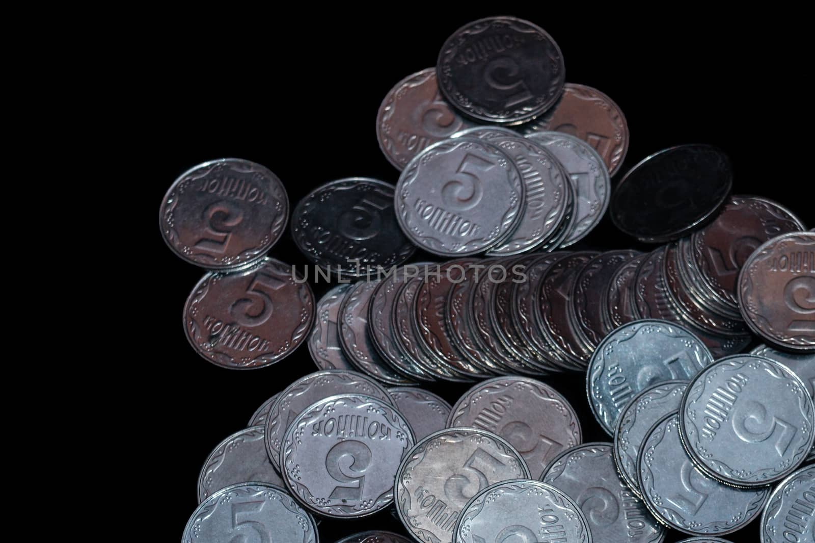 Small Ukrainian coins isolated on black background. Close-up view.