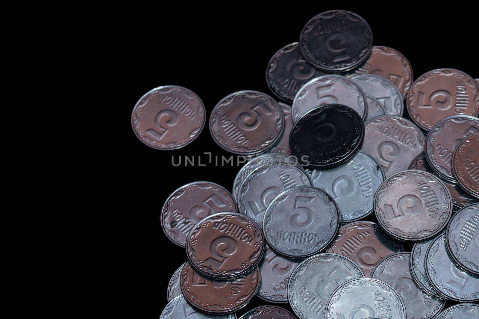 Small Ukrainian coins isolated on black background. Close-up view.