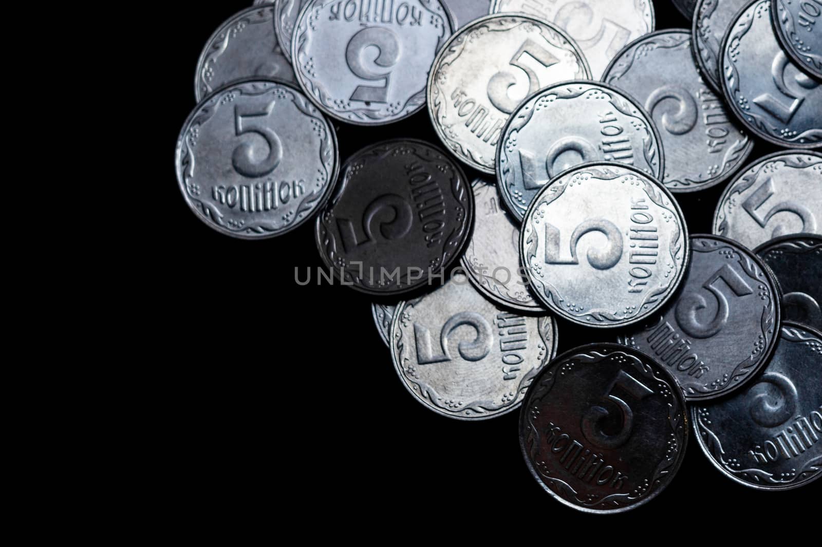 Ukrainian coins isolated on black background. Close-up view. Coins are located above the right side of frame. A conceptual image.