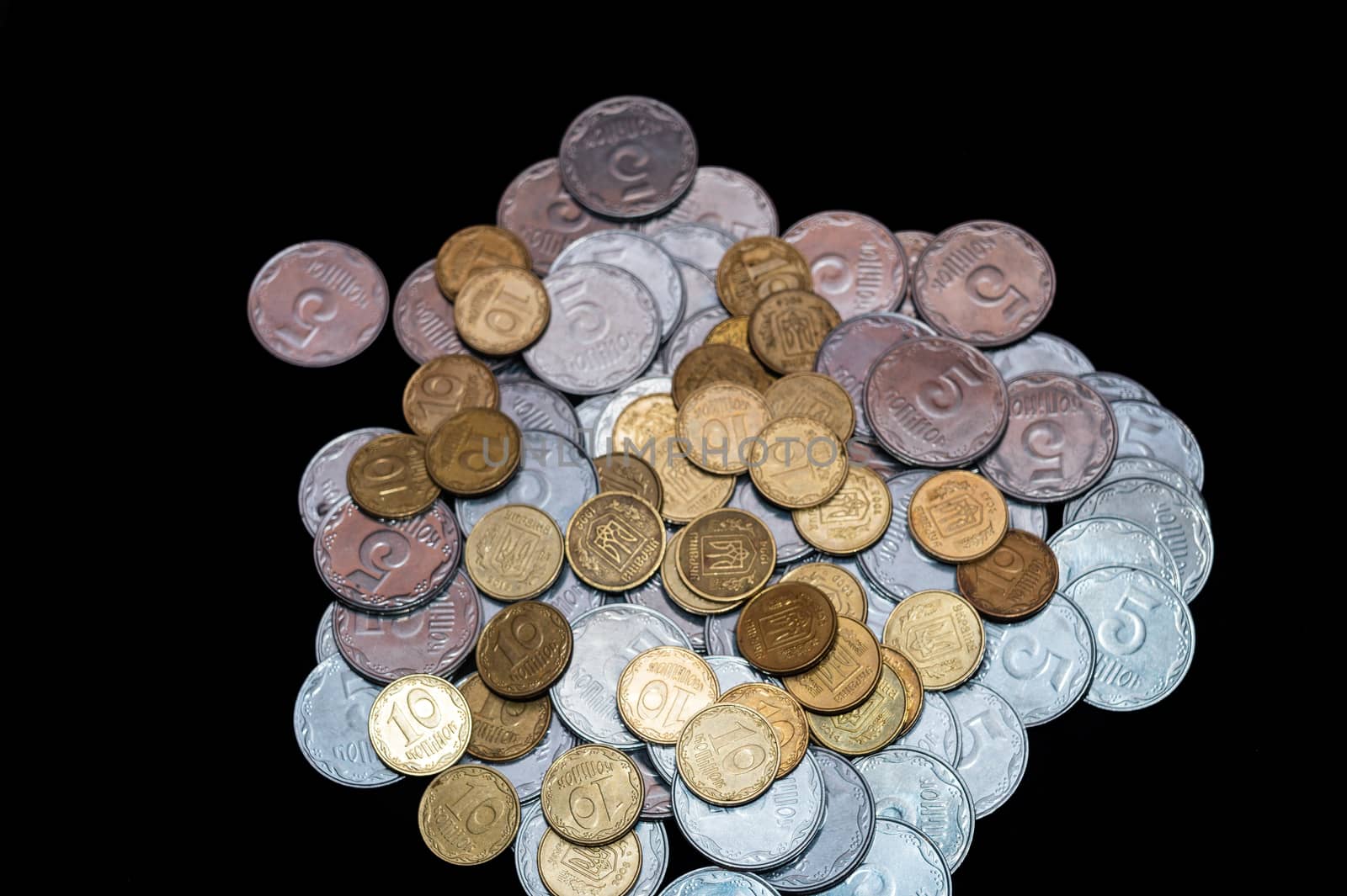 Small Ukrainian coins isolated on black background. Close-up view.