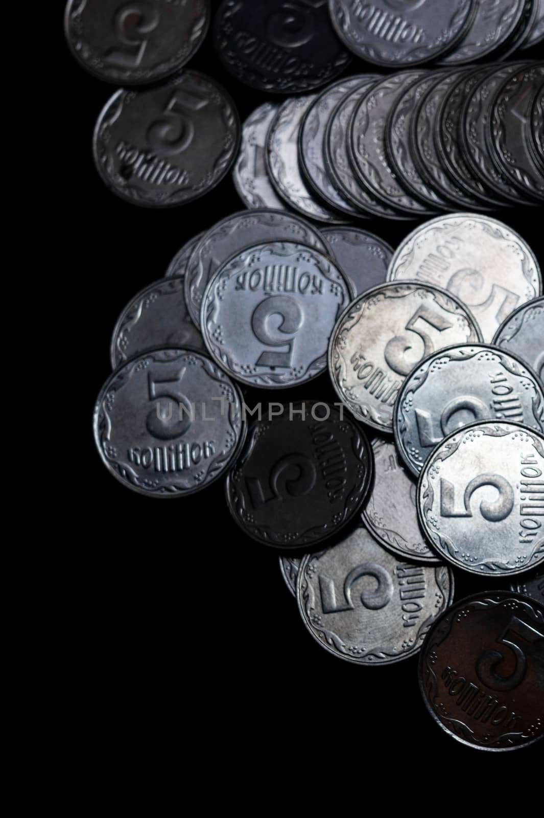 Ukrainian coins isolated on black background. Close-up view. Coins are located above the right side of frame. A conceptual image.