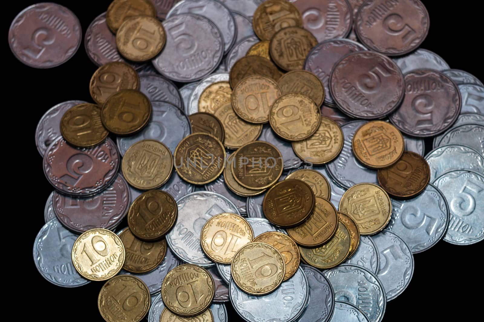 Small Ukrainian coins isolated on black background. Close-up view.