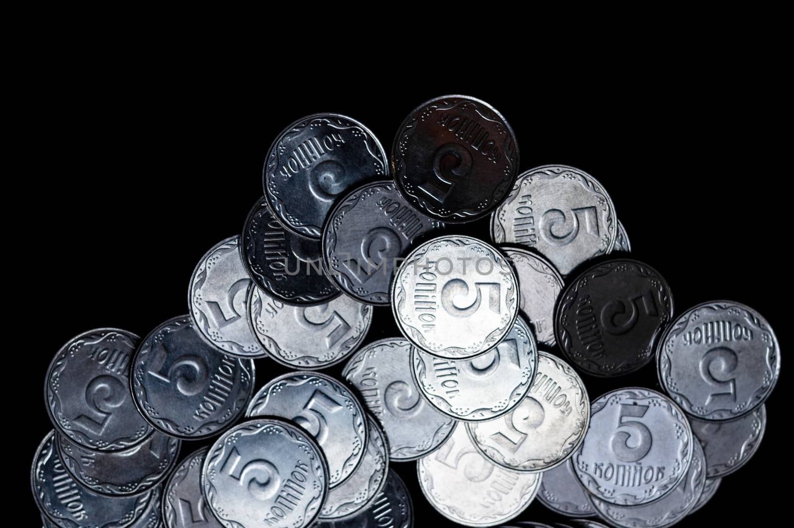 Ukrainian coins isolated on black background. Close-up view. Coins are located below the center of frame. A conceptual image.