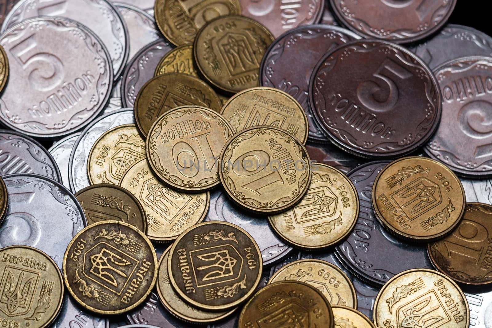 Small Ukrainian coins isolated on black background. Close-up view.