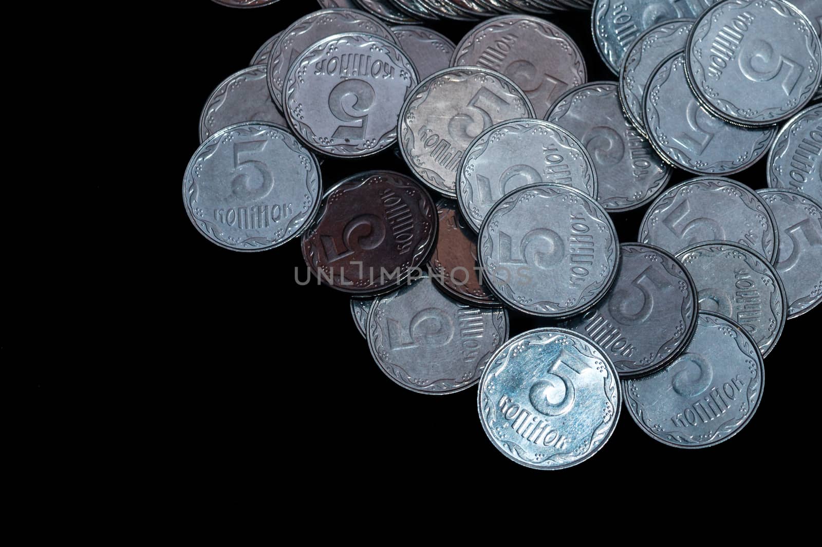 Small Ukrainian coins isolated on black background. Close-up view.