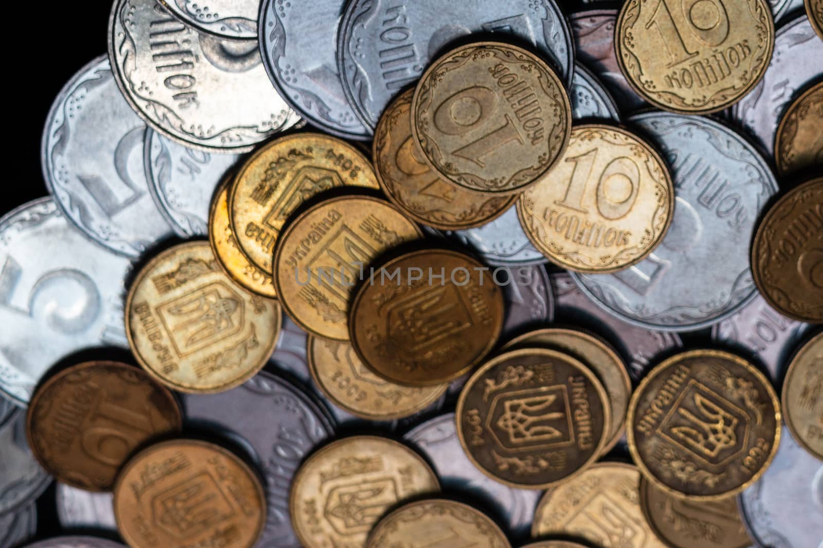 Small Ukrainian coins isolated on black background. Close-up view.