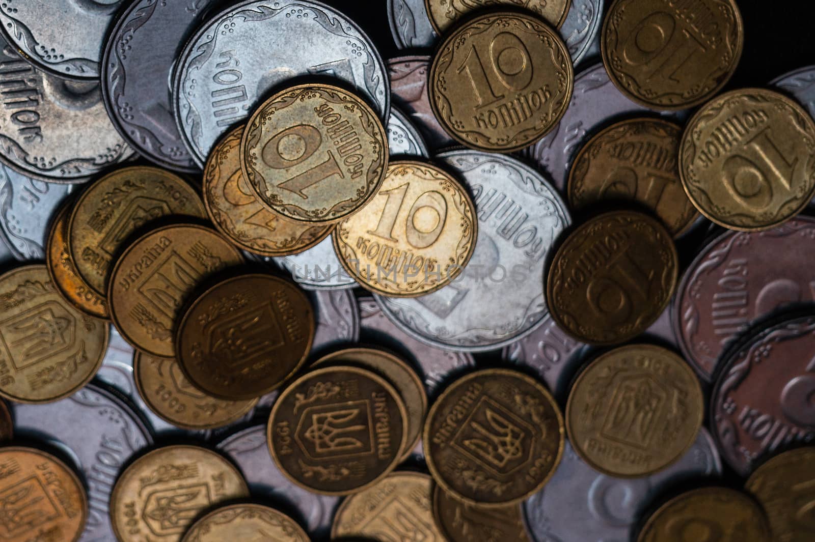 Small Ukrainian coins isolated on black background. Close-up view.
