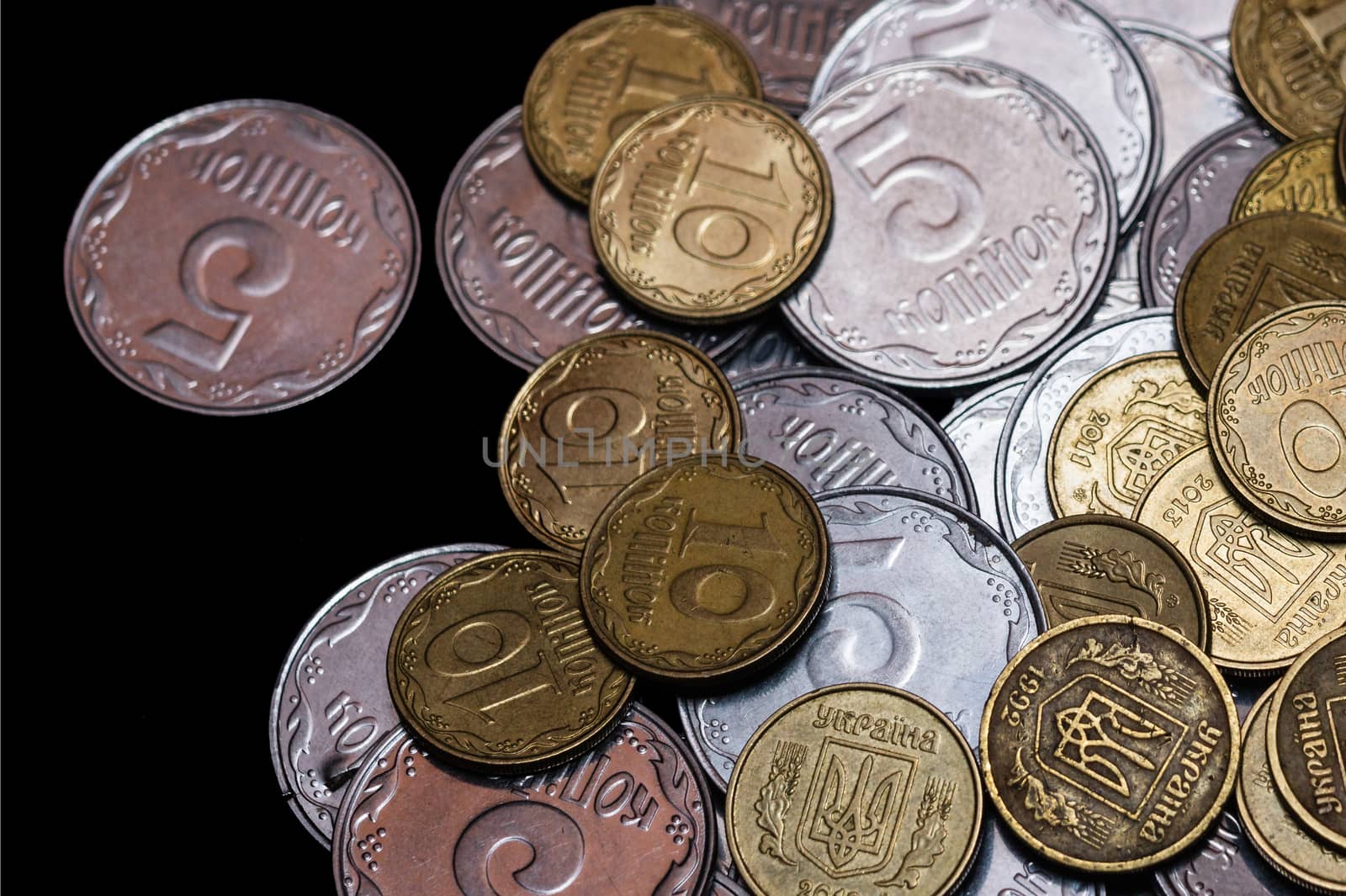 Small Ukrainian coins isolated on black background. Close-up view.