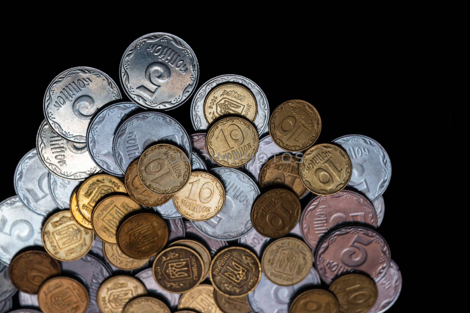 Small Ukrainian coins isolated on black background. Close-up view.