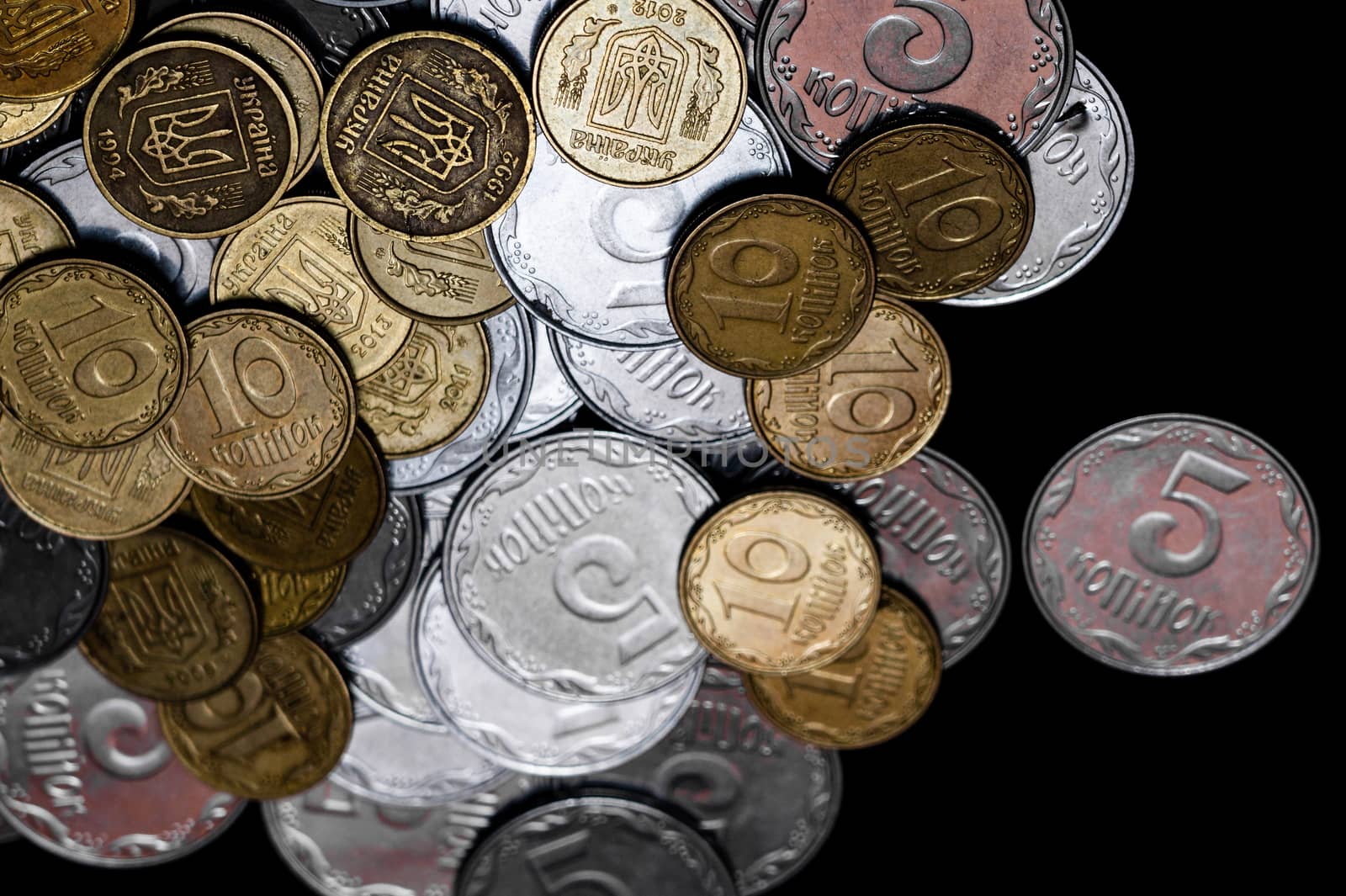Ukrainian coins isolated on black background. Close-up view. Coins are located at the left side of frame. A conceptual image.