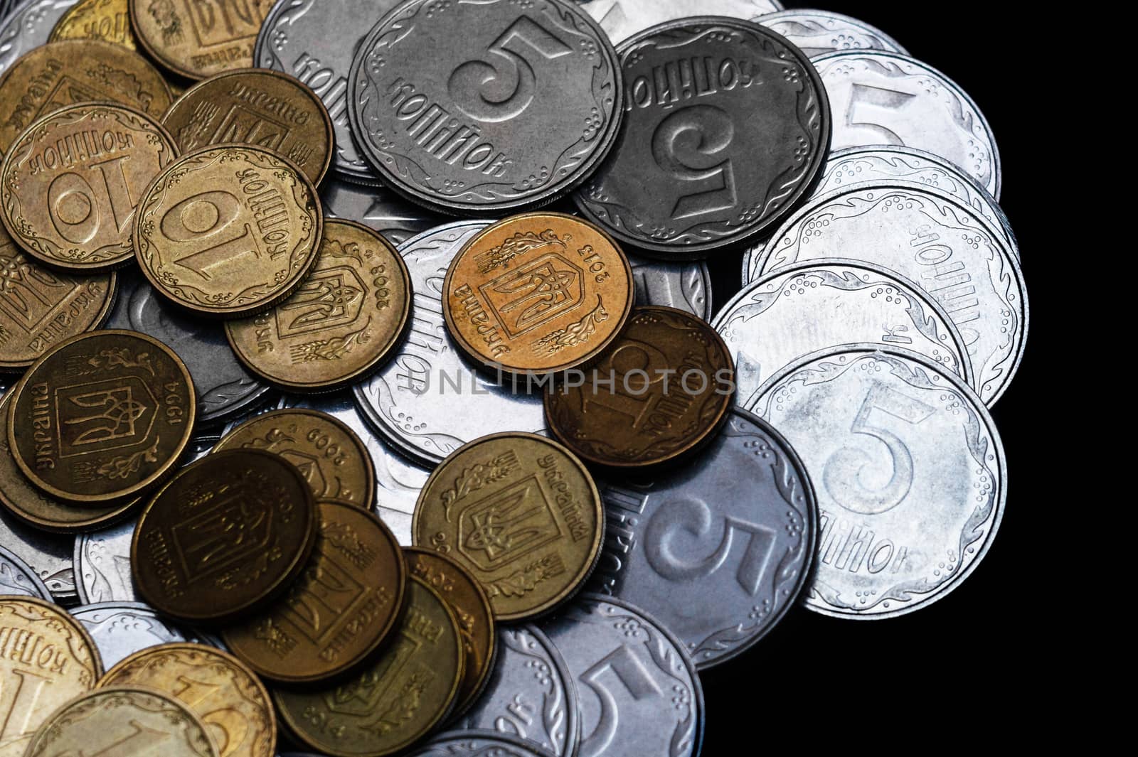 Ukrainian coins isolated on black background. Close-up view. Coins are located at the left side of frame. A conceptual image.
