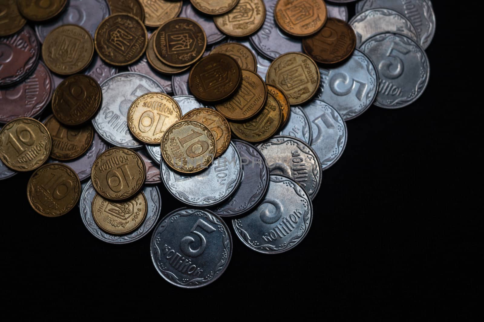 Small Ukrainian coins isolated on black background. Close-up view.
