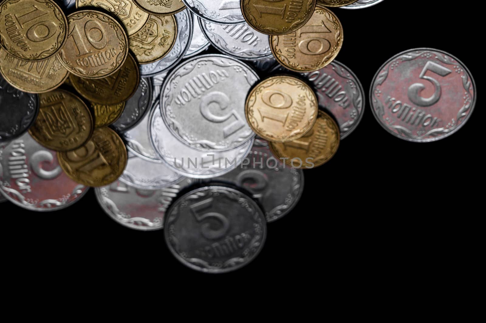 Ukrainian coins isolated on black background. Close-up view. Coins are located above the center of frame. A conceptual image.
