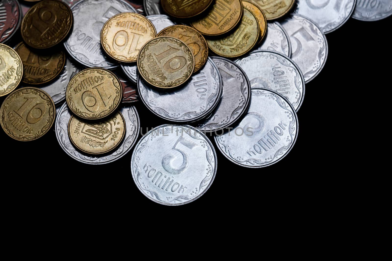 Ukrainian coins isolated on black background. Close-up view. Coins are located above the center of frame. A conceptual image.
