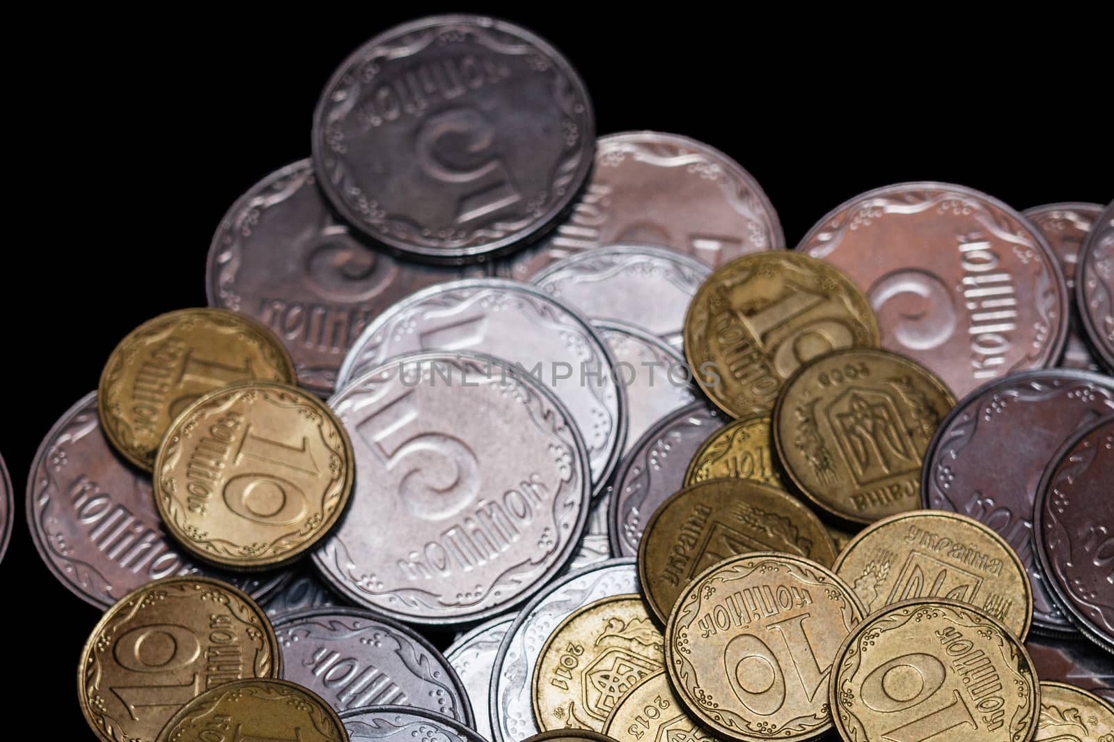Small Ukrainian coins isolated on black background. Close-up view.