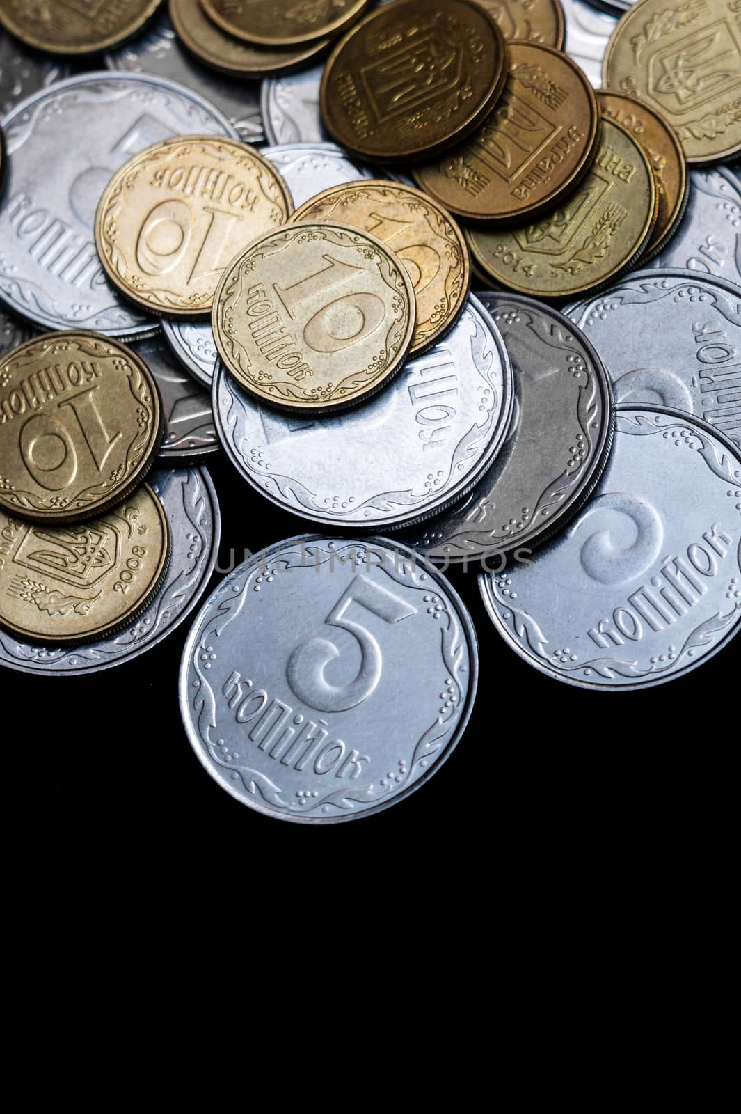 Ukrainian coins isolated on black background. Close-up view. Coins are located above the center of frame. A conceptual image.