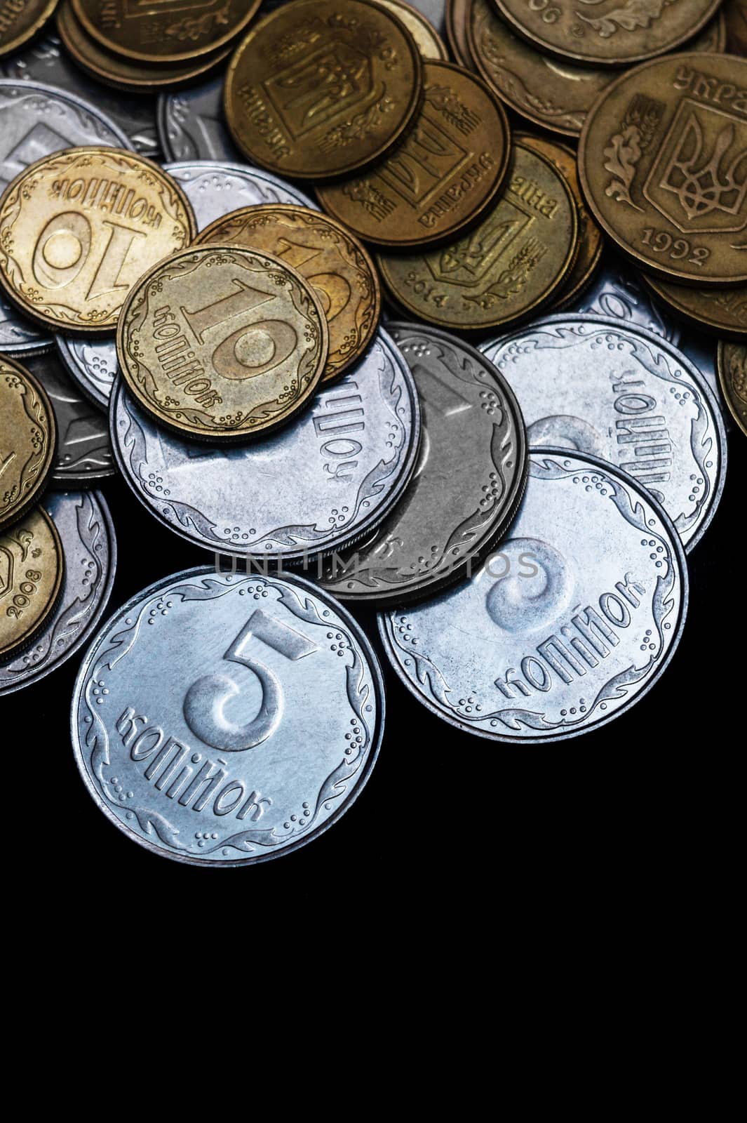 Ukrainian coins isolated on black background. Close-up view. Coins are located above the center of frame. A conceptual image.