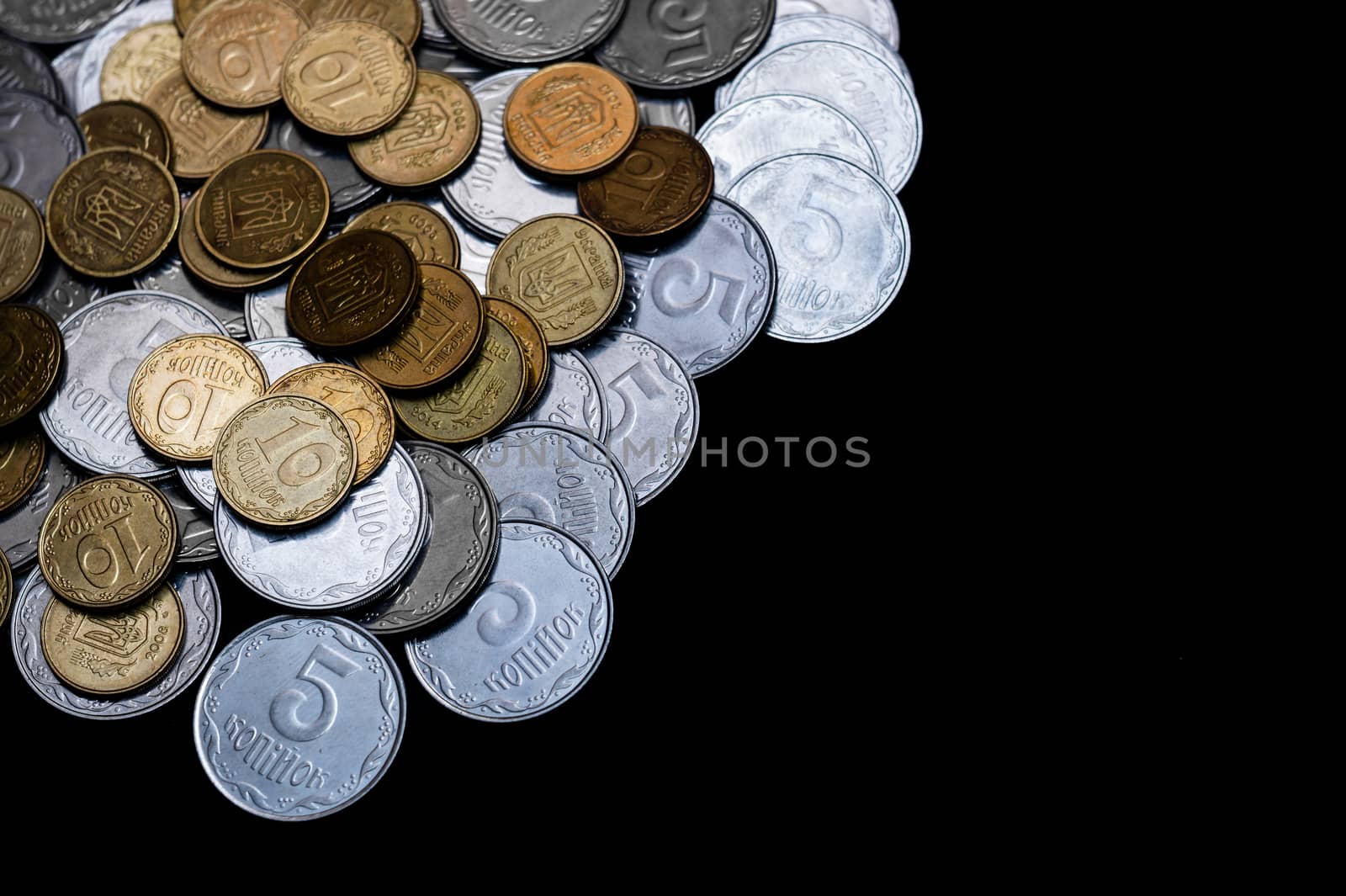 Ukrainian coins isolated on black background. Close-up view. Coins are located left-upper corner of image. A conceptual image.
