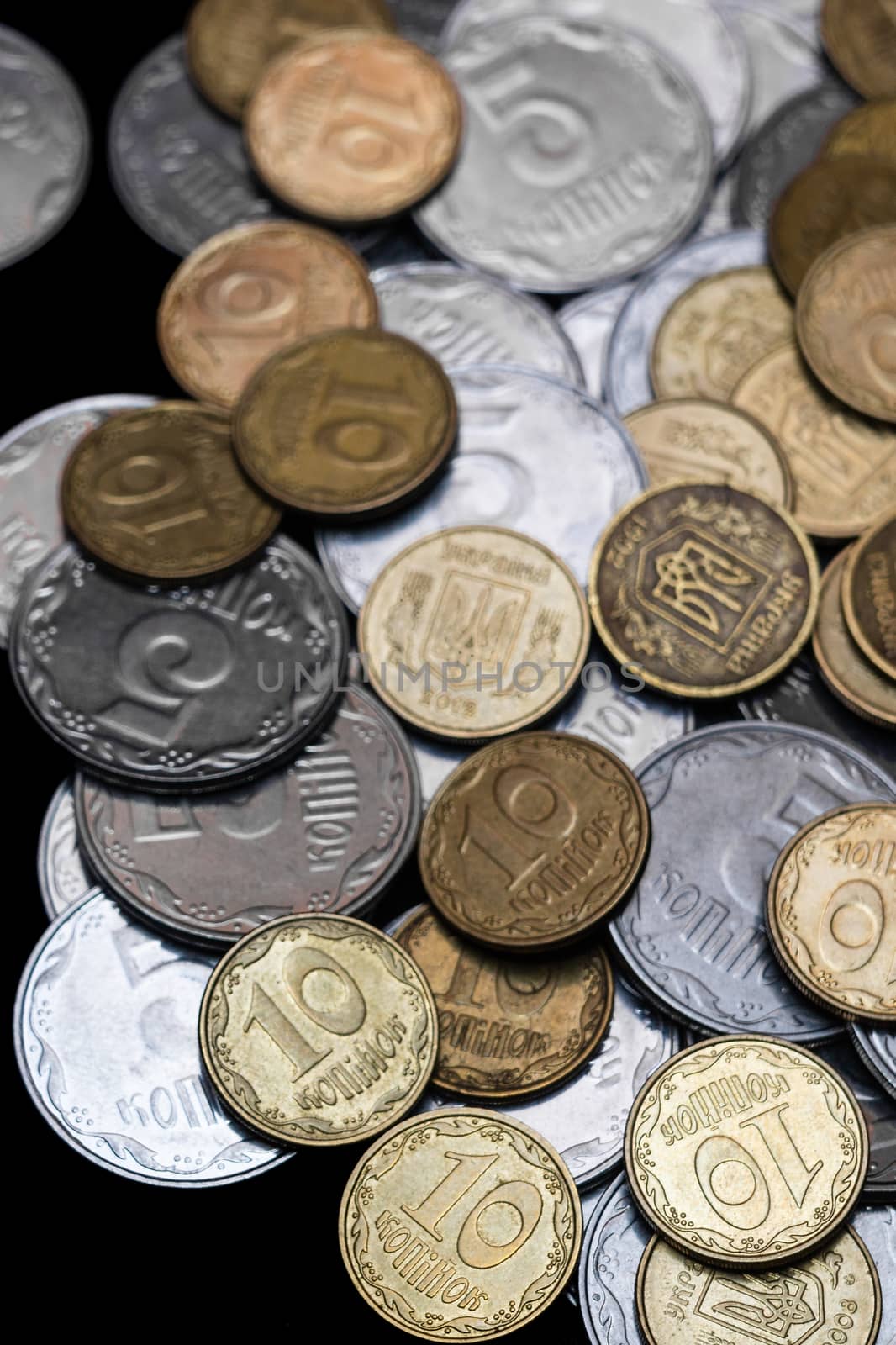 Ukrainian coins isolated on black background. Close-up view. Coins are located at the right side of frame. A conceptual image.