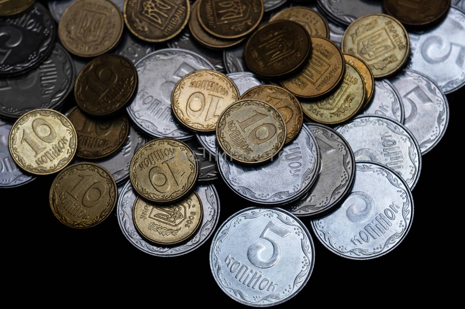 Ukrainian coins isolated on black background. Close-up view. Coins are located above the center of frame. A conceptual image.