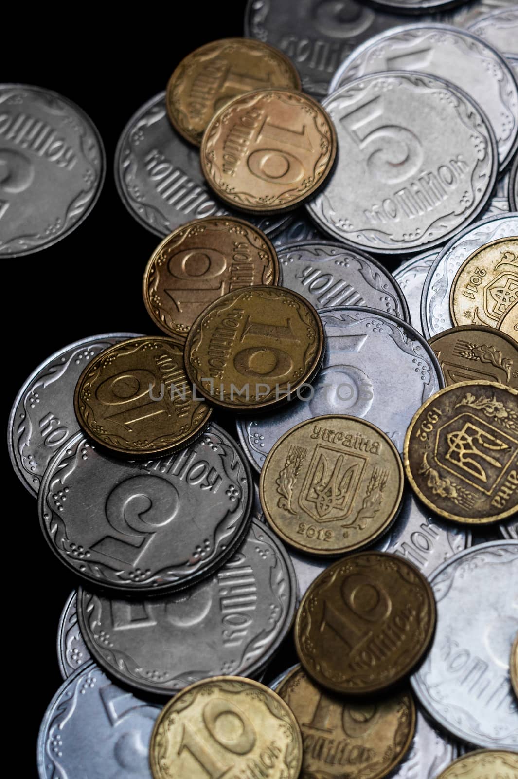 Ukrainian coins isolated on black background. Close-up view. Coins are located at the right side of frame. A conceptual image.