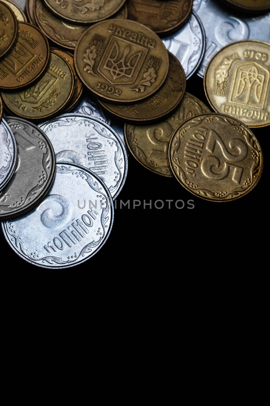 Ukrainian coins isolated on black background. Close-up view. Coins are located above the center of frame. A conceptual image. by alexsdriver