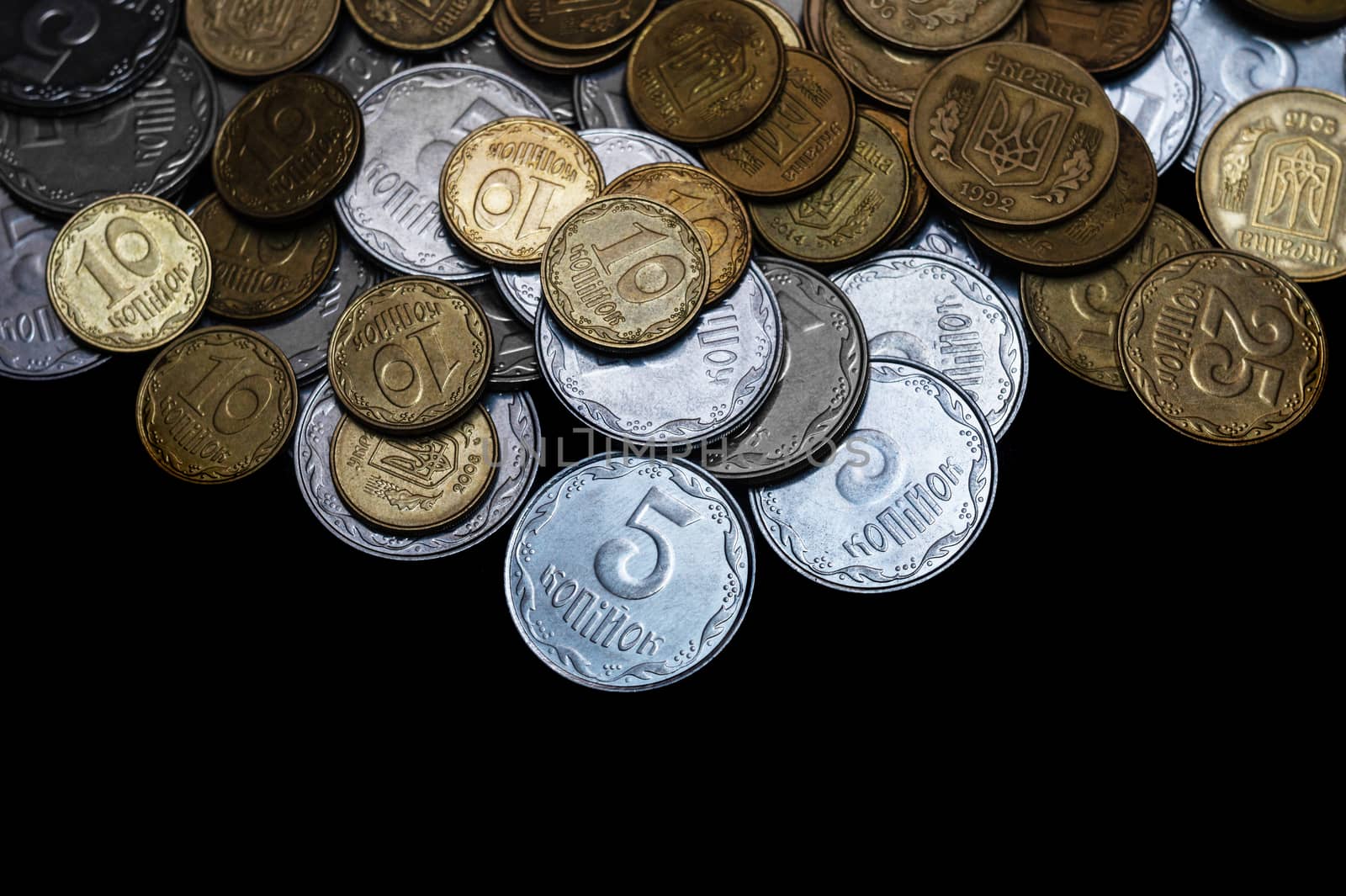 Ukrainian coins isolated on black background. Close-up view. Coins are located above the center of frame. A conceptual image.