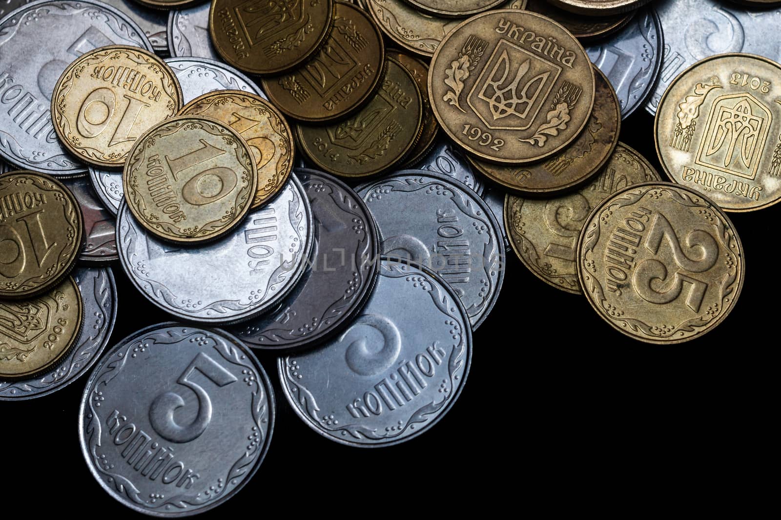 Ukrainian coins isolated on black background. Close-up view. Coins are located above the center of frame. A conceptual image.