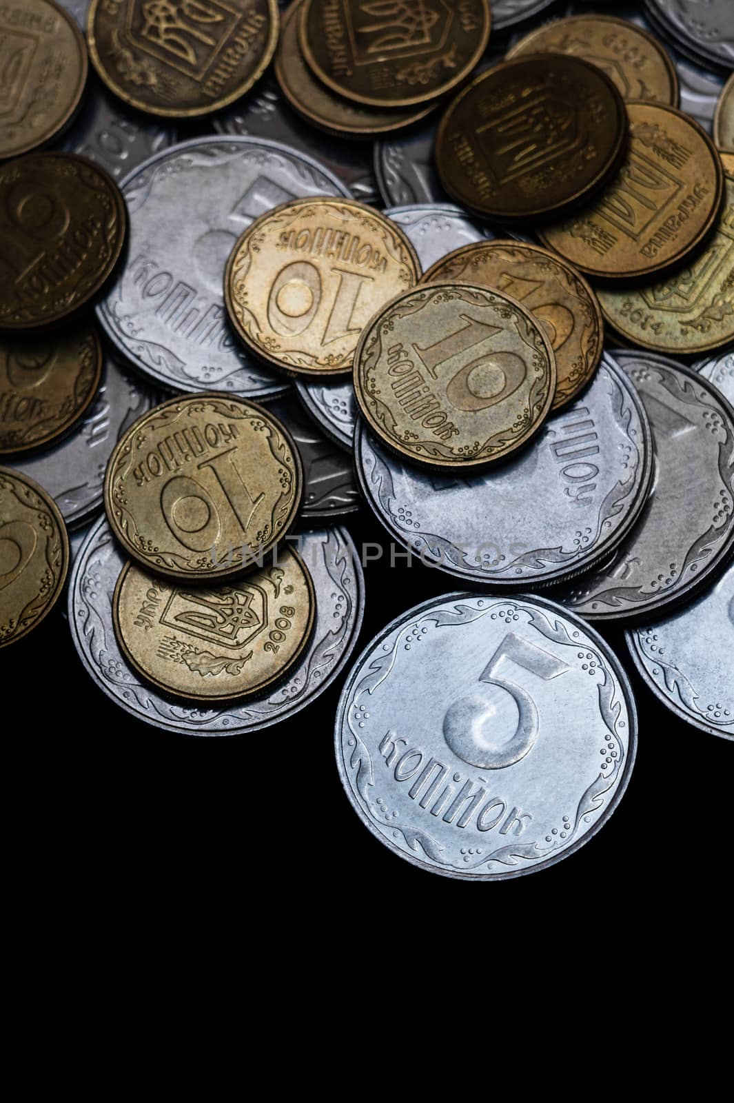 Ukrainian coins isolated on black background. Close-up view. Coins are located above the center of frame. A conceptual image. by alexsdriver