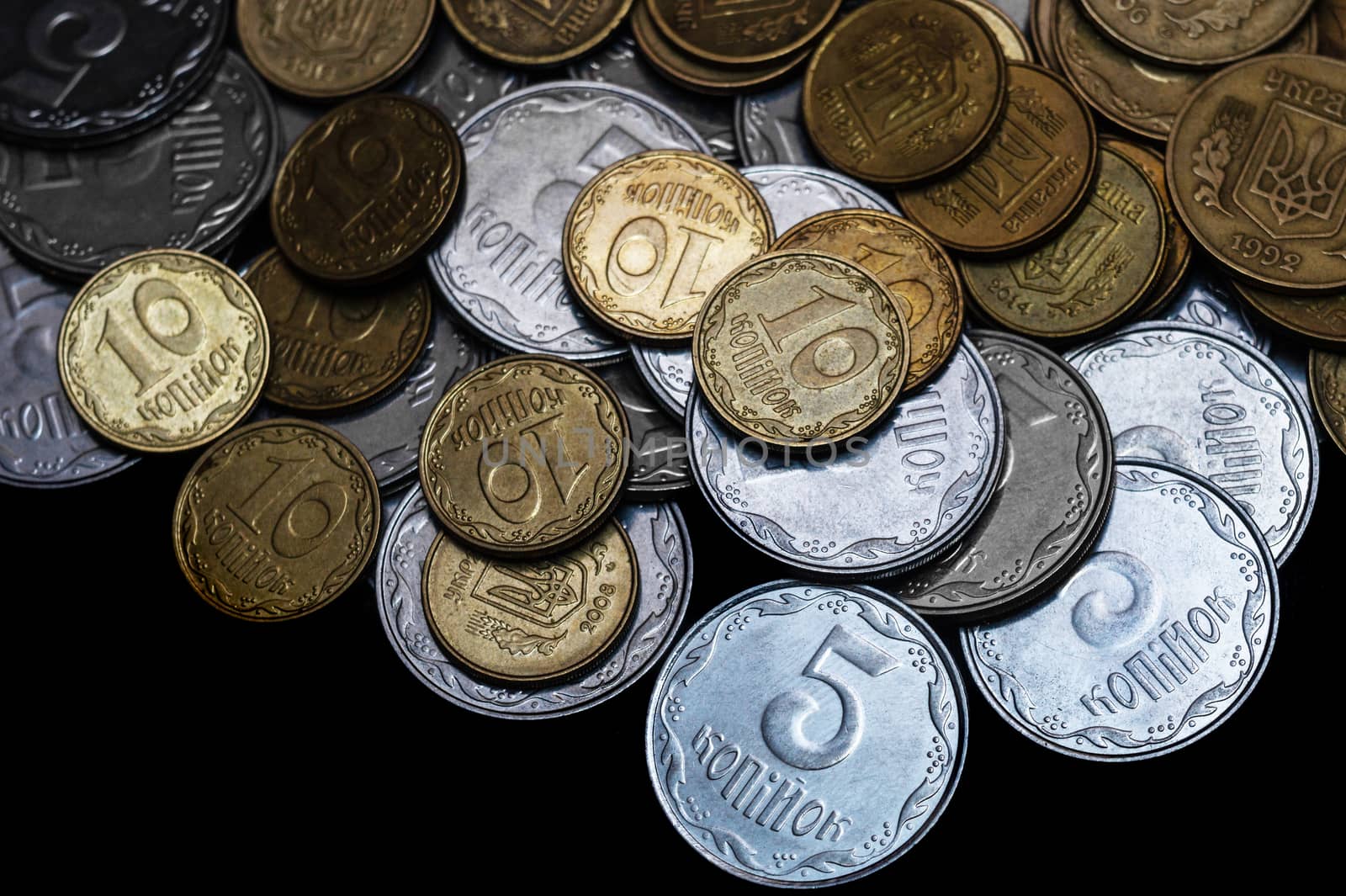 Ukrainian coins isolated on black background. Close-up view. Coins are located above the center of frame. A conceptual image.