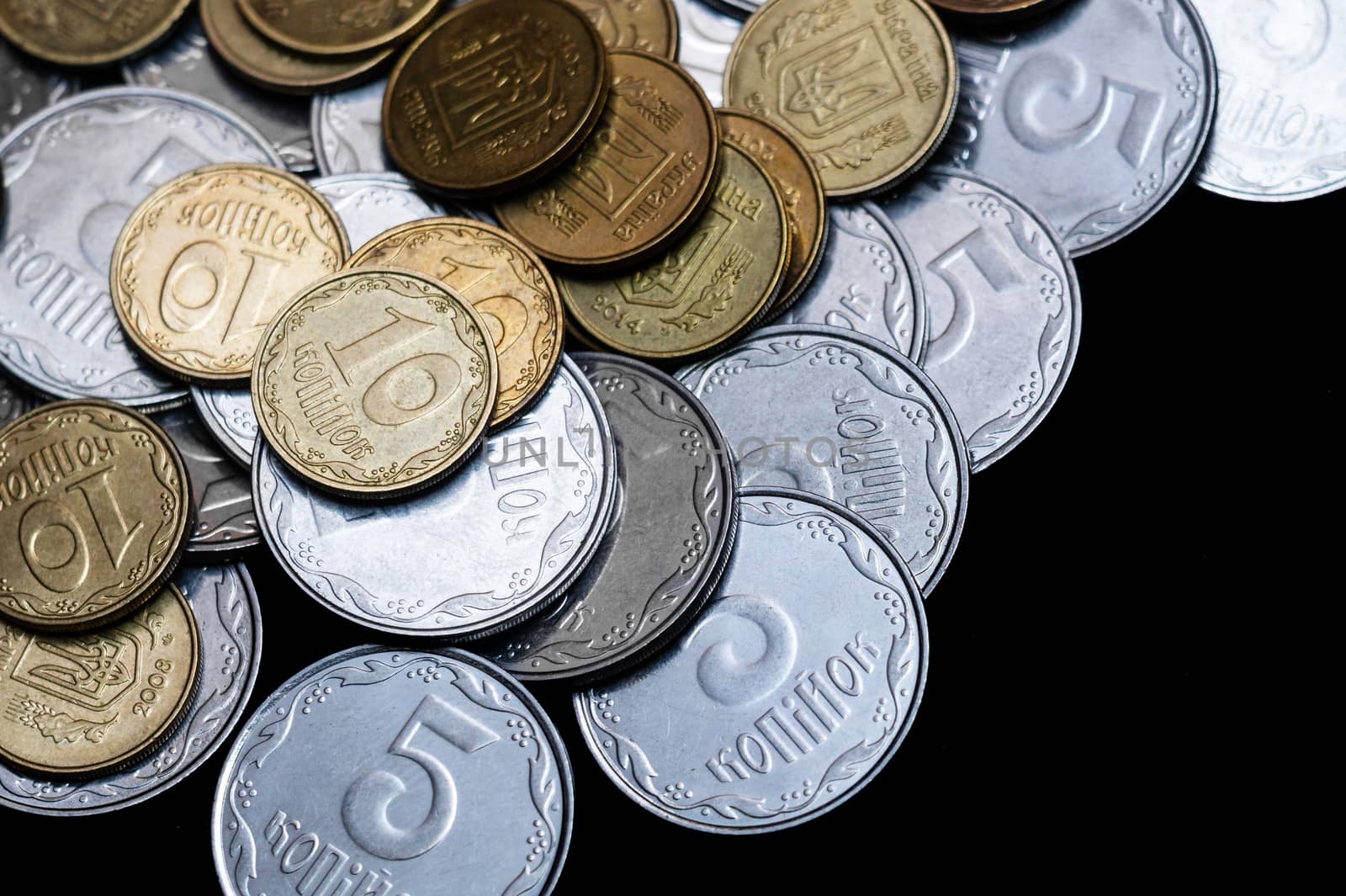 Ukrainian coins isolated on black background. Close-up view. Coins are located above the center of frame. A conceptual image.