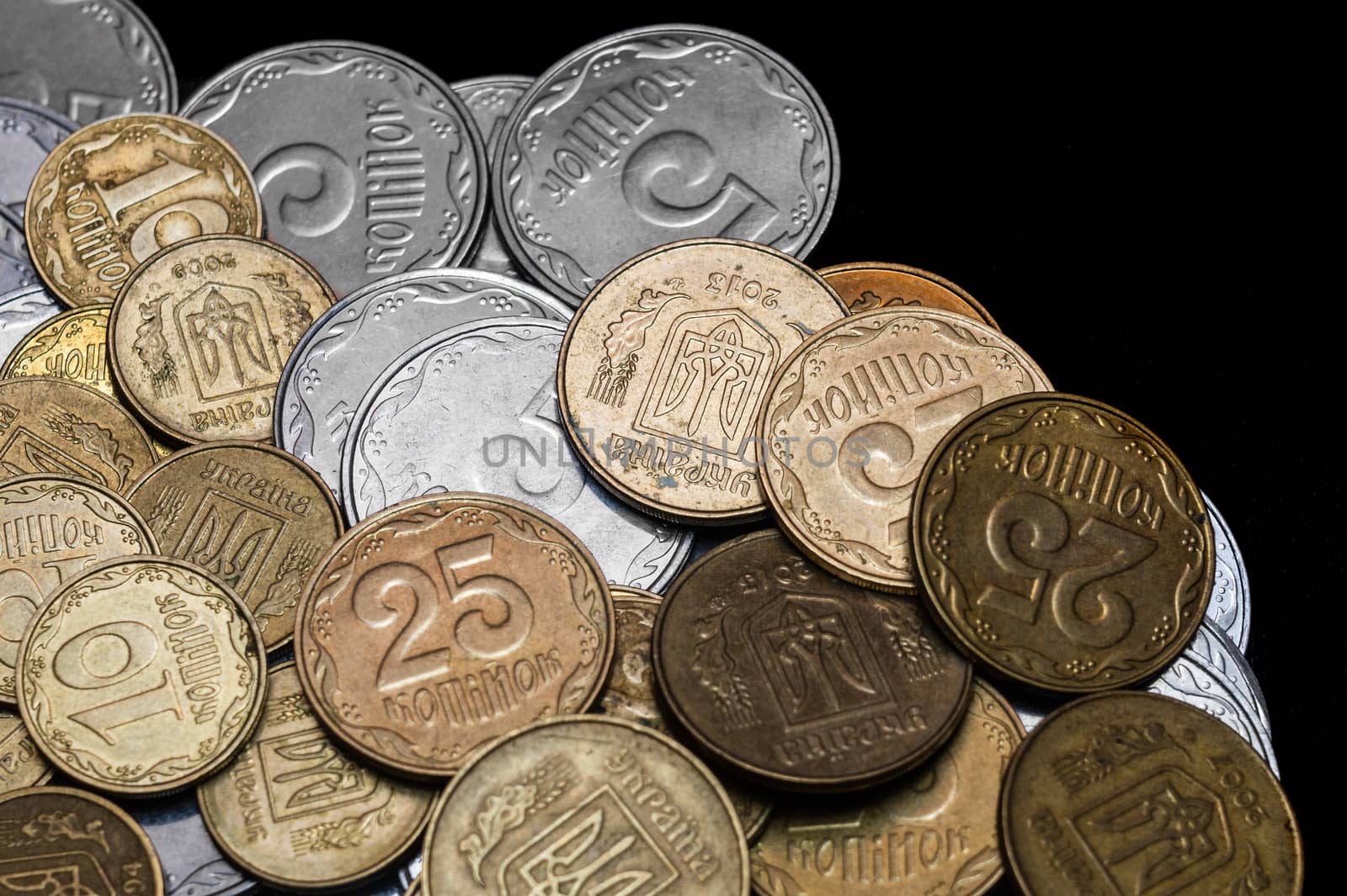 Ukrainian coins isolated on black background. Close-up view. Coins are located at the left side of frame. A conceptual image.